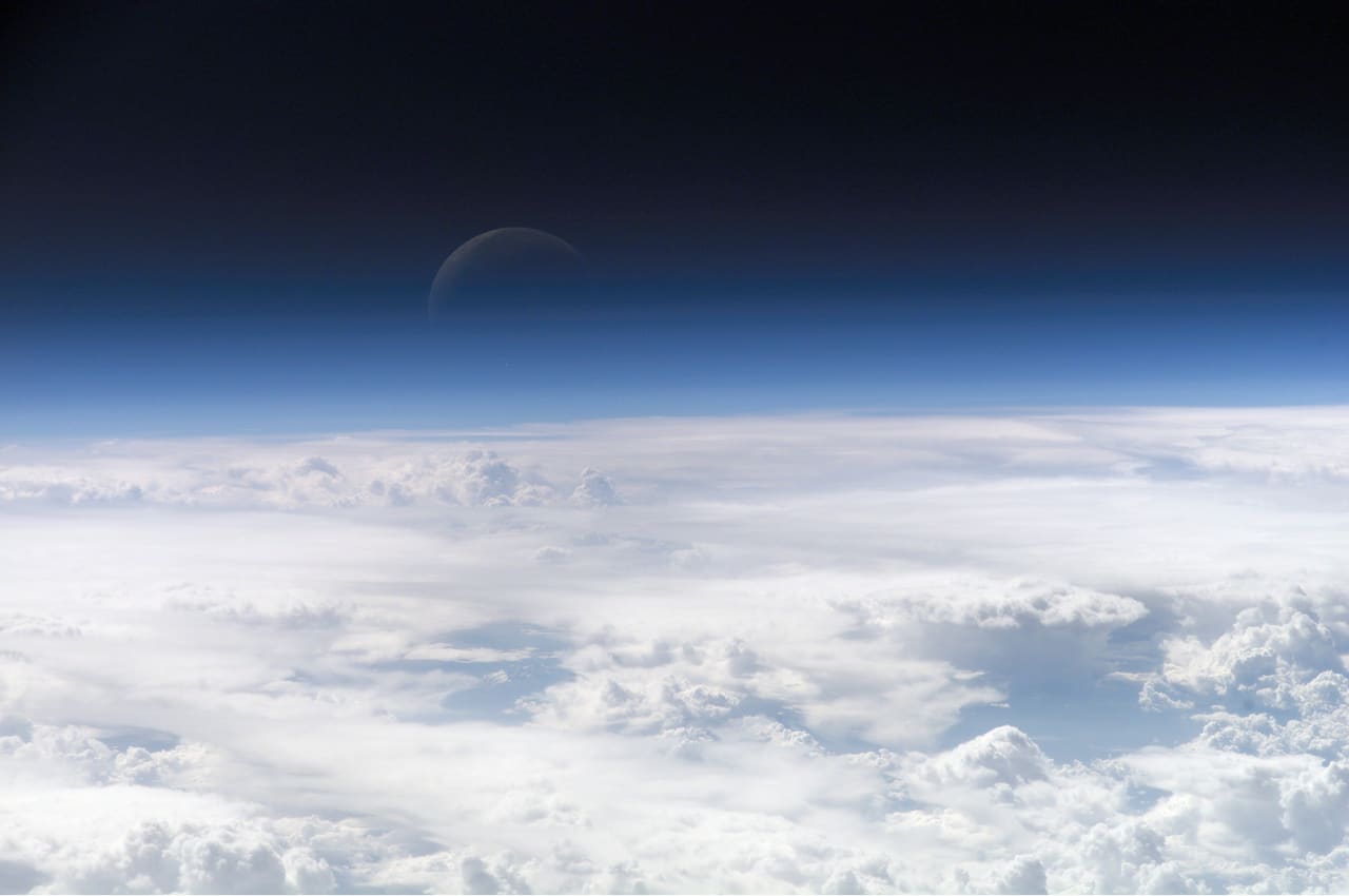 Earth's thin blue atmosphere seen edge-on from orbit, the layer that pulls satellites back down